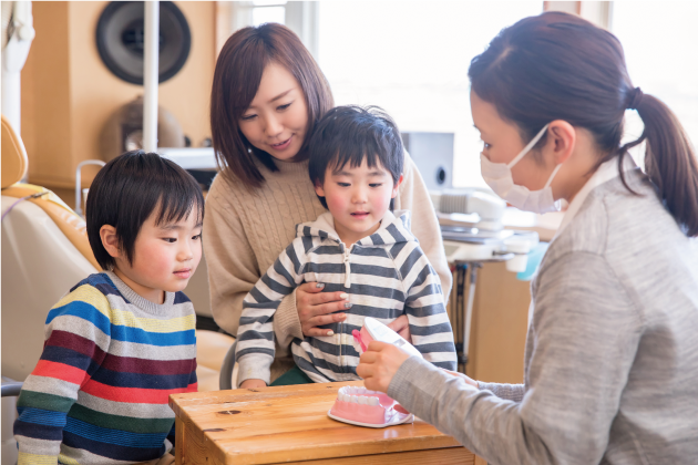 歯科衛生士に歯磨き指導を受ける子ども