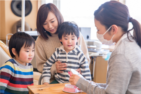 歯科衛生士に歯磨き指導を受ける子ども